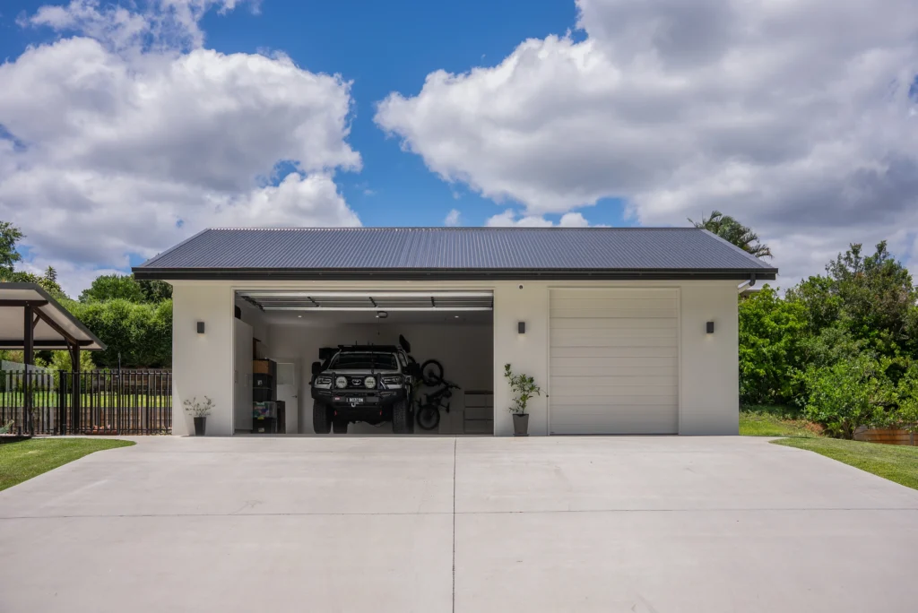 Custom triple garage with Colorbond roof, rendered walls and large concrete driveway, Sunshine Coast by Bozcon Construct