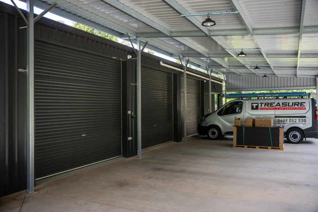 Large custom Colorbond shed with roller doors, industrial lighting and polished concrete floor at Railway Parade, Sunshine Coast by Bozcon Construct