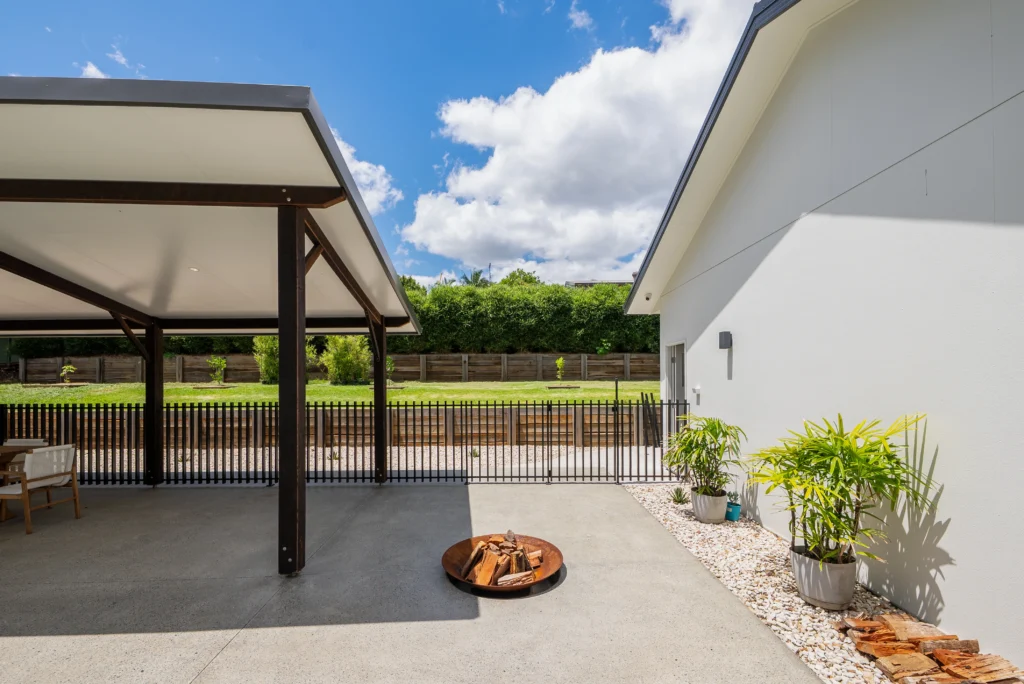 Custom outdoor entertaining area with timber pergola, concrete patio, fire bowl and steel fencing, Sunshine Coast by Bozcon Construct
