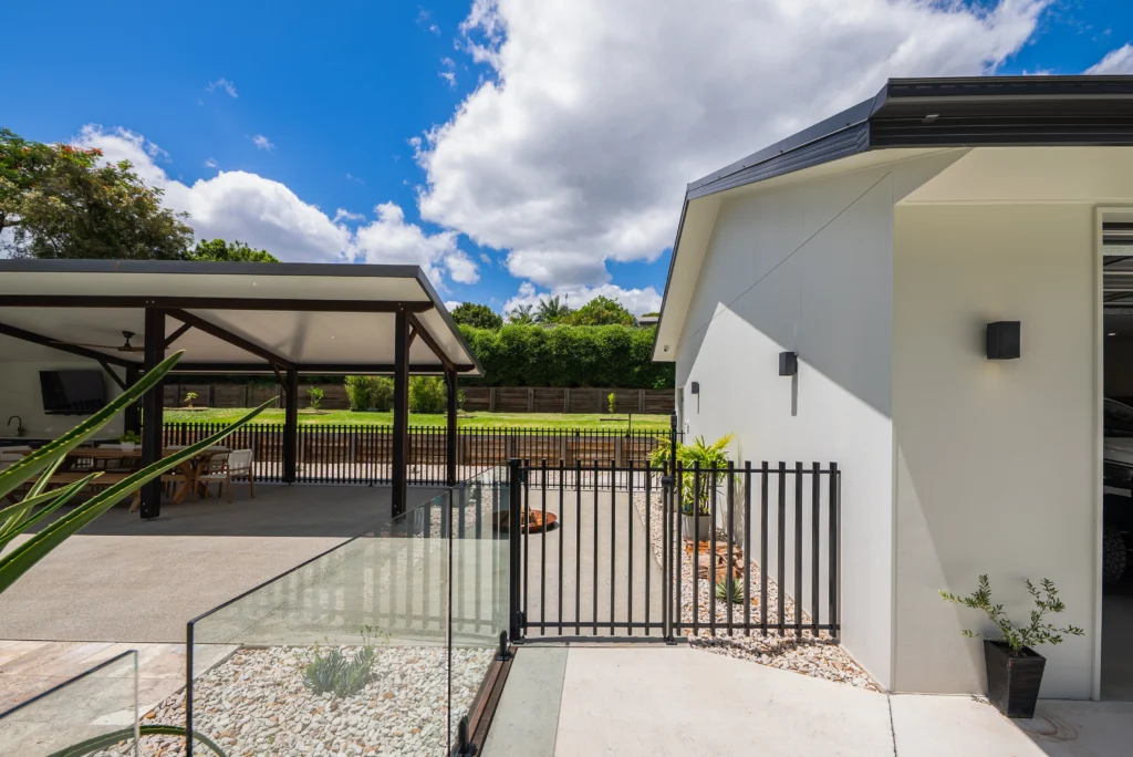 Modern home exterior with rendered walls, glass pool fencing, steel balustrades and covered alfresco, Sunshine Coast by Bozcon Construct