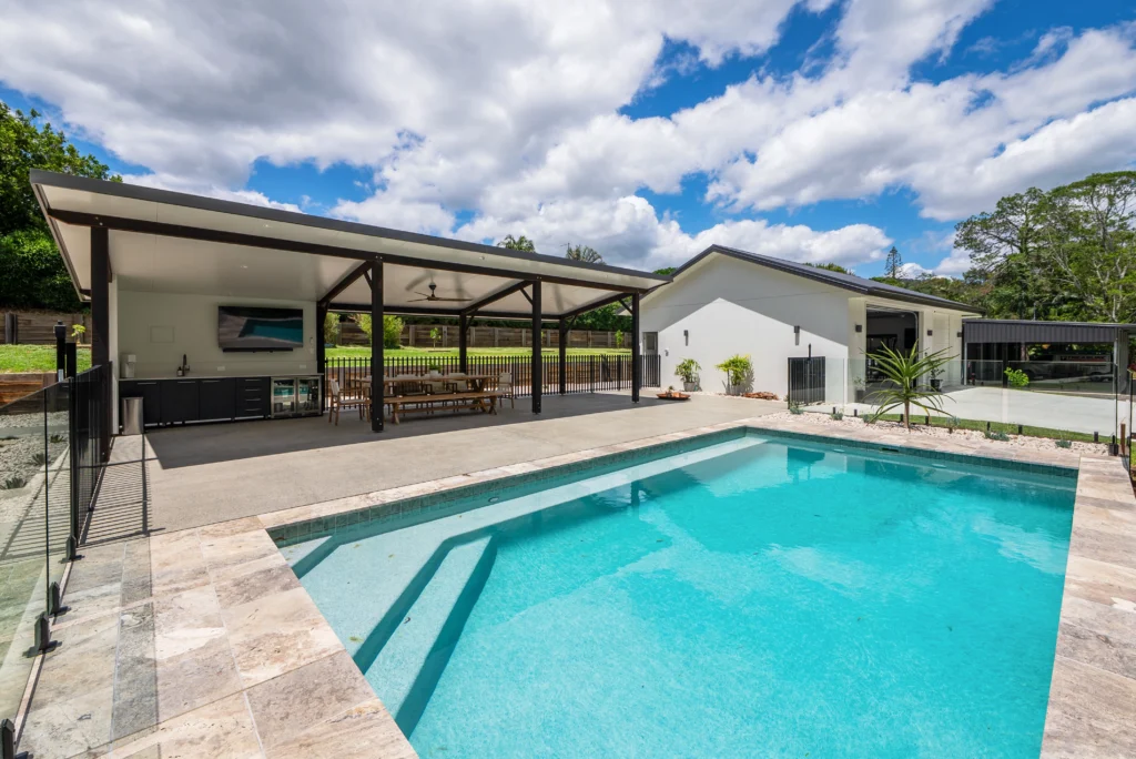 Completed in-ground swimming pool with travertine coping, covered alfresco entertaining area and outdoor kitchen, Sunshine Coast by Bozcon Construct