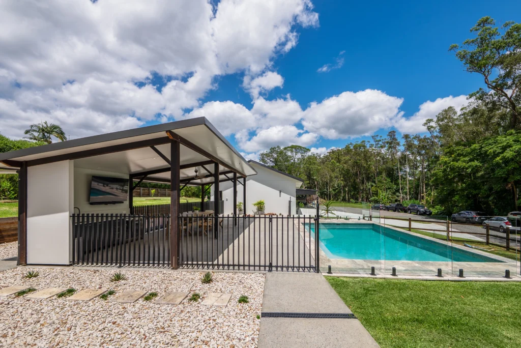 Outdoor entertaining area with covered alfresco, outdoor TV, in-ground pool and steel fencing, Sunshine Coast by Bozcon Construct