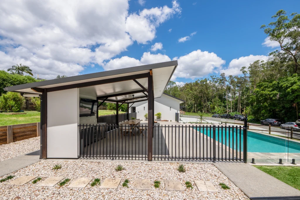 Custom outdoor entertaining area with covered alfresco, swimming pool and black steel fencing, Sunshine Coast by Bozcon Construct