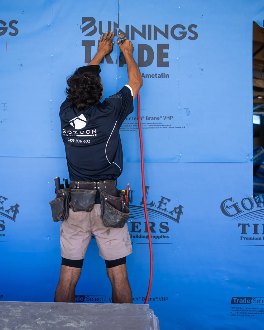 Bozcon Construct tradie installing external wall wrap during a home extension build, Sunshine Coast